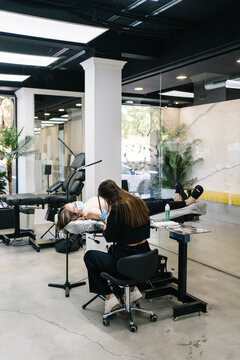 Woman doing tattoo to client