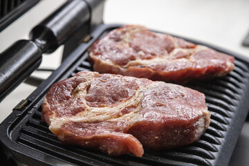 Fresh red meat steak on the grill in the kitchen