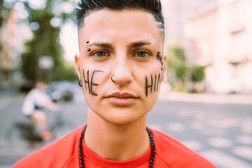Young woman with text written on face in pride event