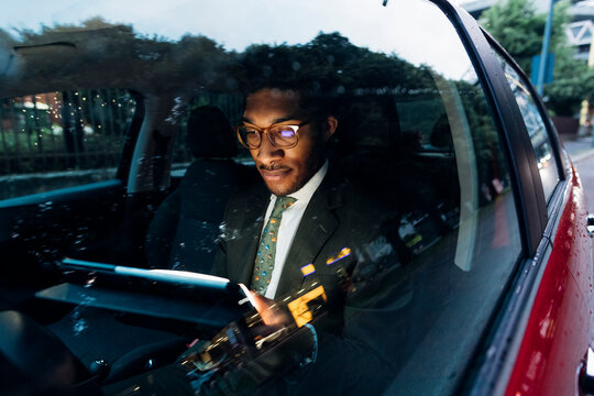 Young businessman using digital tablet while sitting in car