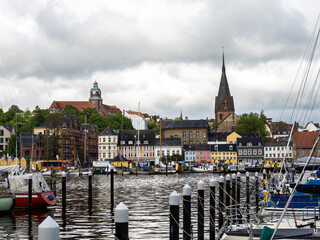 Fototapeta premium Sail boats in the port of Flensburg, St. Jorgen's Church in the background. Schleswig-Holstein in Germany