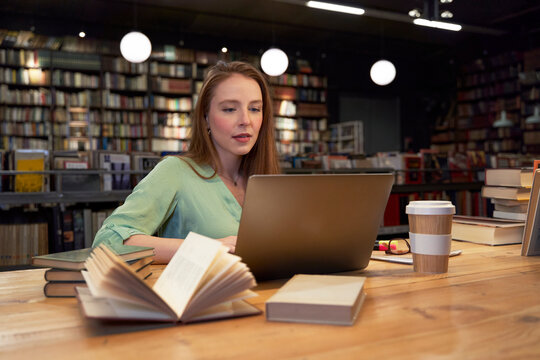 Beautiful woman using laptop while studying in library