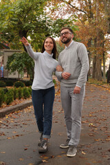 Happy couple wearing stylish clothes in autumn park