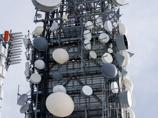 Group of antennas, satellite dishes for telecommunications, television broadcast, cellphone, radio and satellite on Linzone mountain peak. Electromagnetic and environmental pollution. Italian Alps