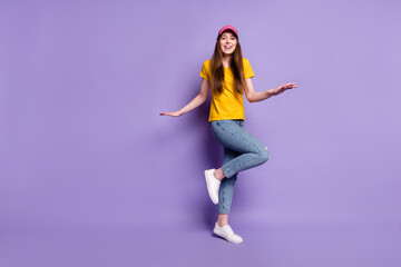 Fototapeta na wymiar Full length photo of happy cheerful young woman wear jeans headwear street style isolated on violet color background
