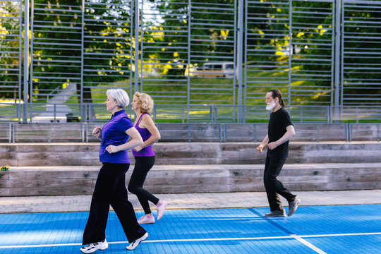 Old People Jogging On Track In Early Morning 