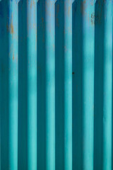 Corrugated waved cyan color fence under sunlight.