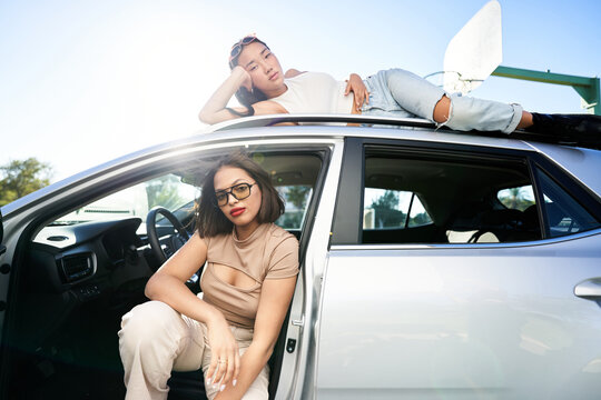 Diverse women sitting on SUV car