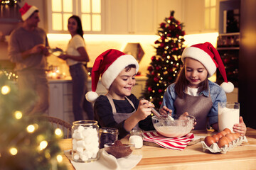 Cute little children making dough for delicious Christmas cookies at home