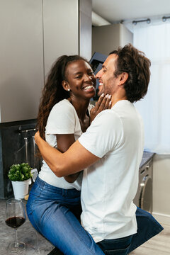 Cheerful couple kissing in kitchen