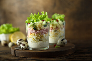 Green salad with ham and cheese served in a glass