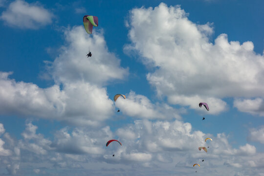 puffy clouds and paragliders