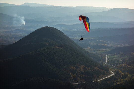 colourful wing flies over rounded mountains