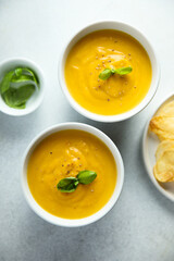 Traditional homemade pumpkin soup with fresh basil