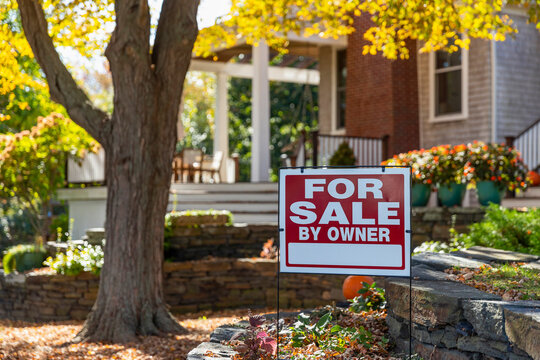 House for Sale sign in front of Residence with foliage