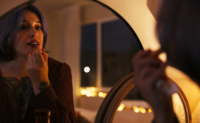 Woman applying lipstick for party