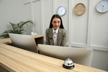 Beautiful receptionist working at counter in hotel