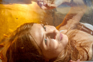 Beautiful girl with long hair underwater in the swimming pool. Young woman and diving