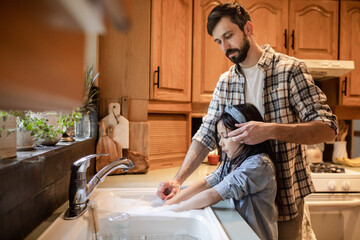 Father Helps Daughter With Hair While Doing Dishes
