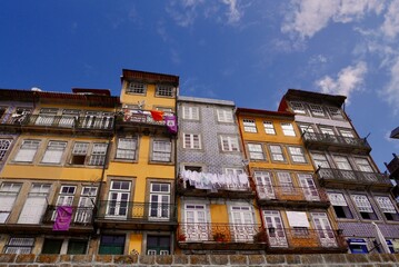 Fototapeta na wymiar Panoramic view of typical colorful houses with ceramic tiles (azulejos) at waterfront in Ribeira. Porto, Portugal.