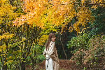 紅葉の公園にいる女性