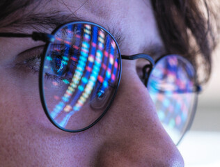 Male teenage scientist with DNA test results reflection on eyeglasses