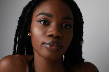 Closeup headshot of a confident black African young woman with braids. Isolated.