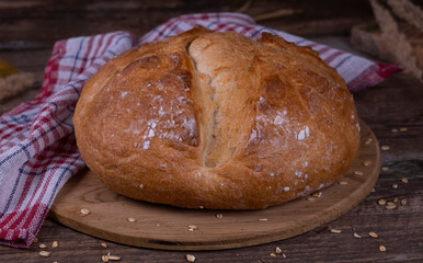 Fresh bread on a wooden close-up. Fresh bread on the kitchen table. Healthy food and traditional bakery concept. rustic