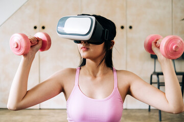 Woman using virtual reality headset while holding dumbbells at home