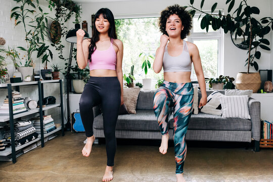 Female friends practicing zumba while exercising in living room