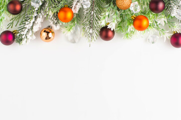 Fir branches with multi-colored Christmas balls, cones, decor on a white background with space for...
