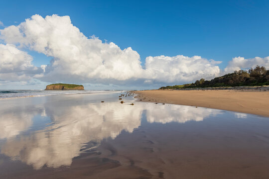 Clouds reflecting in coastal water at Minnamurra Beach with Stack Island in background