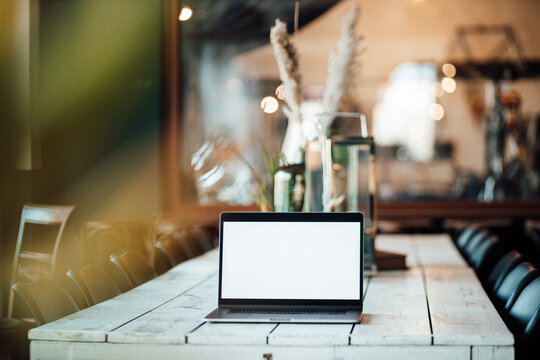 Laptop with blank screen on cafe table