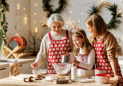 Happy little girl, mother and grandmother cooking traditional christmas gingerbread cookies together