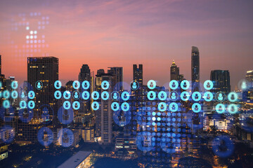 Hologram of social media icons over sunset panoramic cityscape of Bangkok, Southeast Asia. The concept of people connections and career opportunities. Multi exposure.