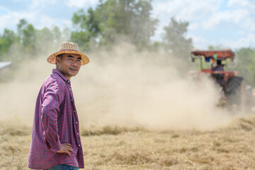 Agricultural tractors are harvesting Pangola grass, where farmers use balers or bales of hay to...