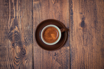 Cup with ready-made coffee on a wooden background. view from above. Selective focus.