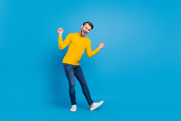 Fototapeta na wymiar Full length body size photo of smiling overjoyed man dancing at party isolated on bright blue color background