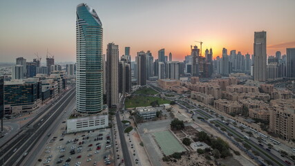 Naklejka na ściany i meble Dubai's business bay towers aerial day to night timelapse. Rooftop view of some skyscrapers