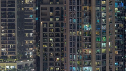 Fototapeta na wymiar Big glowing windows in modern residential buildings timelapse at night