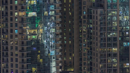 Big glowing windows in modern residential buildings timelapse at night