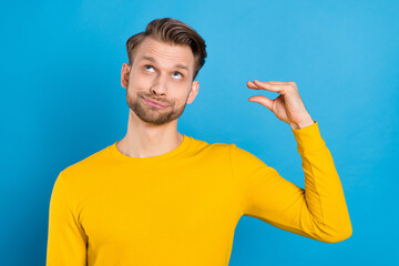 Photo of young man annoyed bored mocking show hands talk speak sign look empty space isolated over...