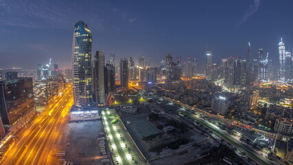 Obraz na płótnie Canvas Dubai's business bay towers aerial night to day timelapse. Rooftop view of some skyscrapers