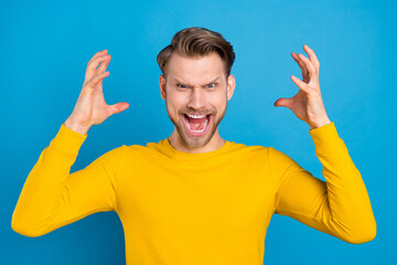 Photo of young angry man aggressive furious scream conflict offensive isolated over blue color background