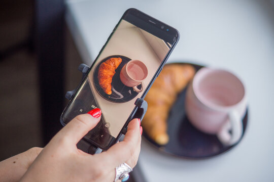 
The girl takes pictures of her breakfast on the phone
