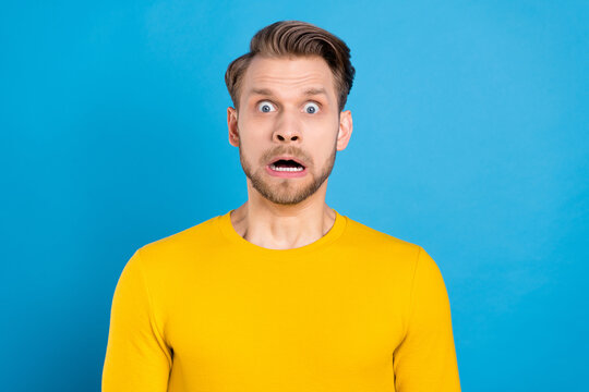 Photo of young man afraid scared panic stupor horrified fail problem isolated over blue color background