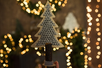 Christmas tree made from natural materials against a background of yellow lights, Christmas wooden tree.