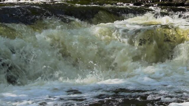 Slow motion river water rushing over the rocks; Ocqueoc Falls, rushing water over rocks in Northwest Michigan after months of rain in late summer--late morning.  25 percent of real time. 436 25