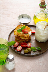 Stack of potatoes fritters served with cherry tomato