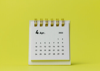 Desktop calendar for April 2022 on a yellow background. - obrazy, fototapety, plakaty